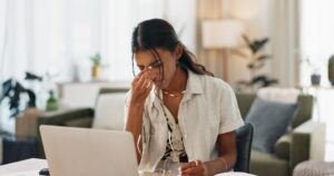 Woman, headache and work from home stress on laptop for marketing mistake, copywriting fail or onli