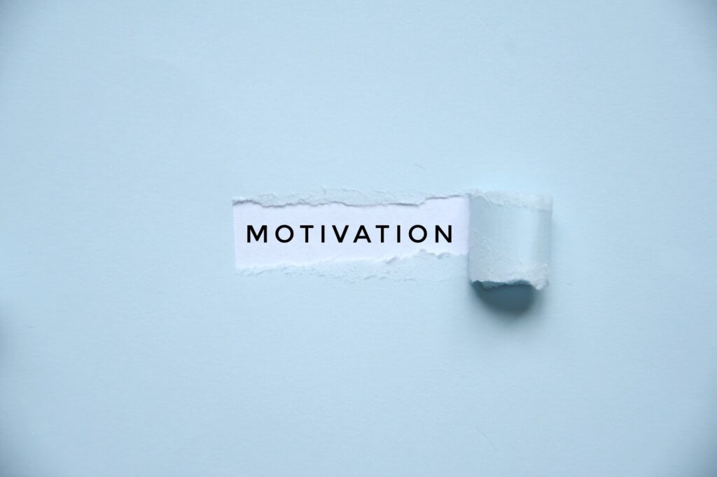 Overhead photo of a light blue paper with a hole where it says motivation