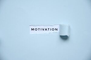 Overhead photo of a light blue paper with a hole where it says motivation