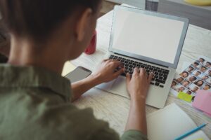 Female photo editor using laptop in creative office