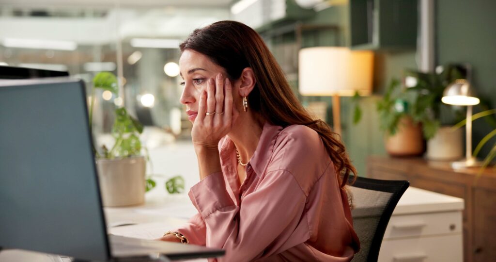 Woman, tired and reading on computer for business, feedback and burnout in office. Mature entrepren